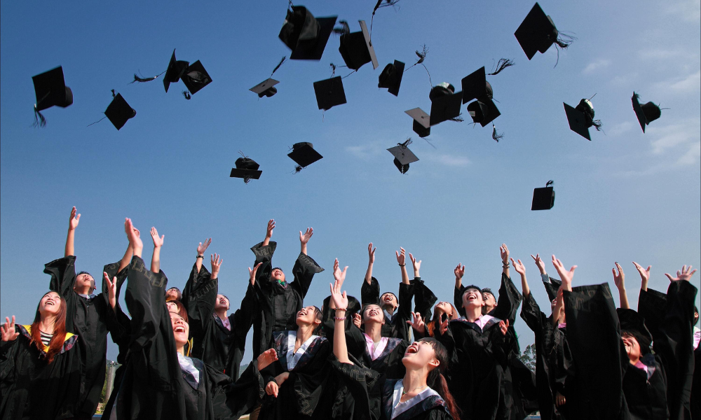 Graduates throwing hats in air